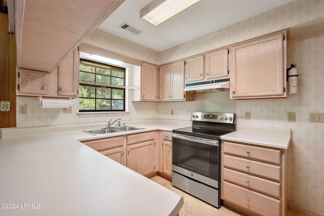 kitchen with stainless steel electric range oven, light brown cabinetry, and sink