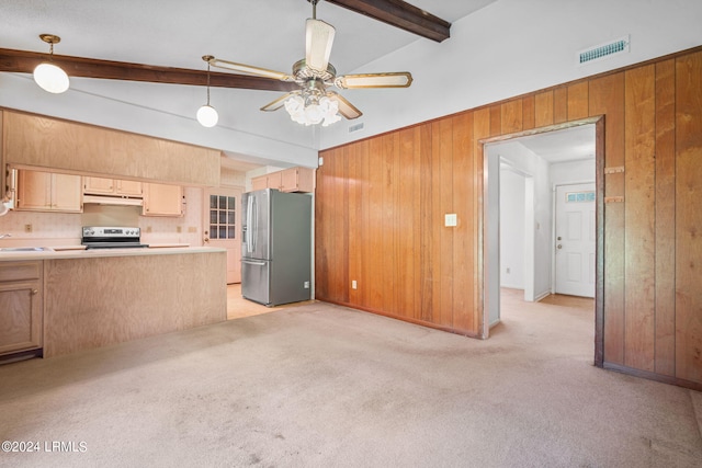 kitchen with sink, wood walls, hanging light fixtures, appliances with stainless steel finishes, and light colored carpet