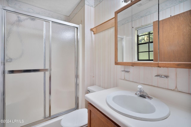 full bathroom featuring vanity, shower / bath combination with glass door, and toilet