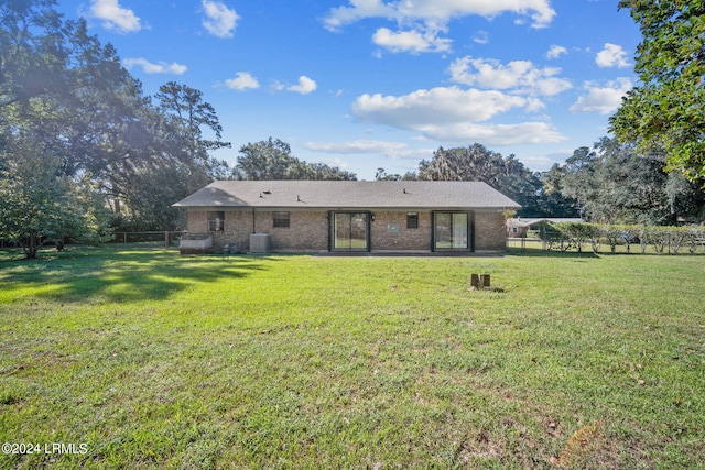 back of property featuring a yard and central air condition unit