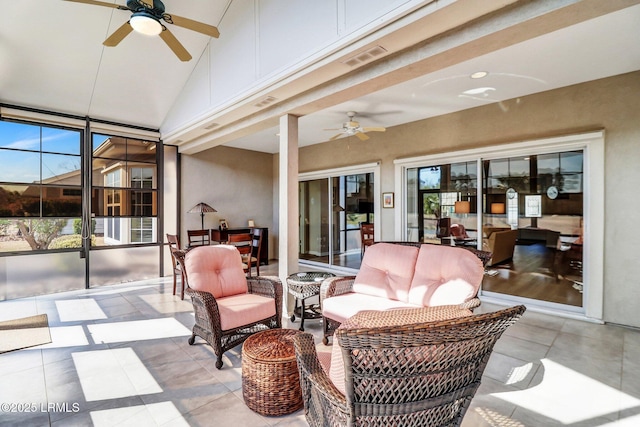 sunroom featuring a healthy amount of sunlight, ceiling fan, and visible vents