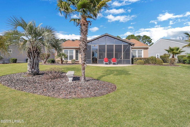 rear view of property with a sunroom, a lawn, and a patio