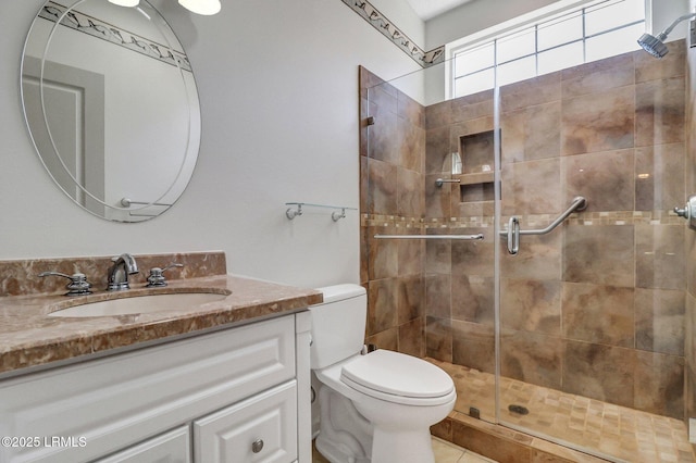 bathroom with toilet, a shower stall, and vanity