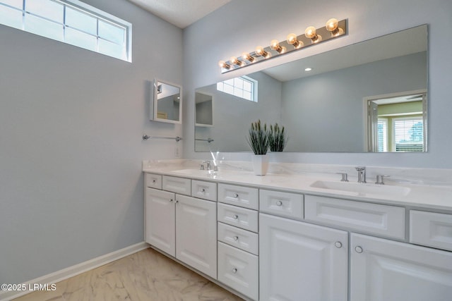 full bath featuring baseboards, marble finish floor, a sink, and a healthy amount of sunlight