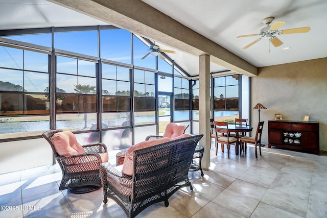 sunroom / solarium with lofted ceiling with beams, a water view, and ceiling fan