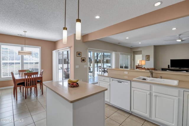 kitchen featuring dishwasher, open floor plan, a healthy amount of sunlight, a sink, and light tile patterned flooring