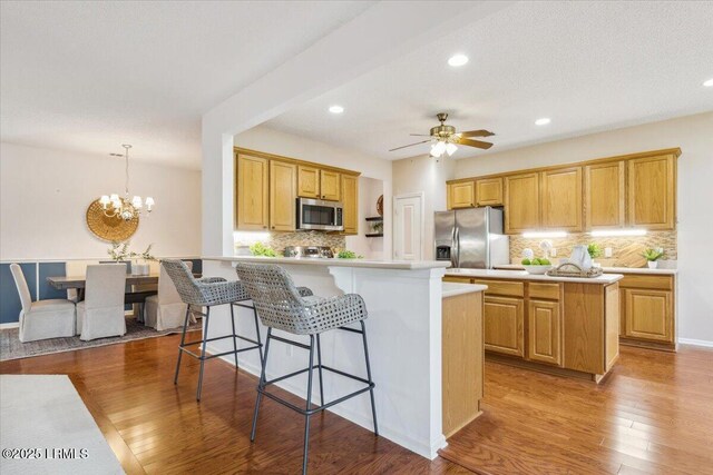 6 Pinyon Dr, Bluffton, SC 29909 - kitchen featuring stainless steel appliances, a center island, light countertops, backsplash, and wood finished floors