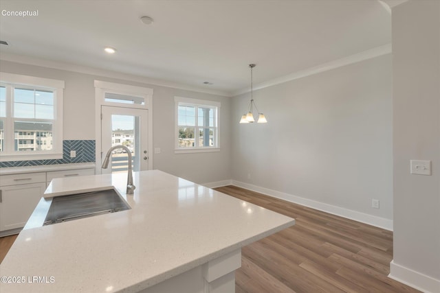 425 Parkside Commons, Bluffton, SC 29910 - kitchen with ornamental molding, wood finished floors, white cabinets, hanging light fixtures, and light stone countertops