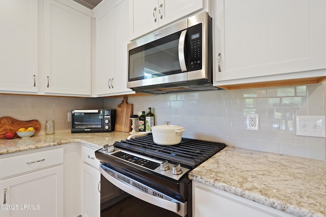 11 Basin Trail St, Beaufort, SC 29902 - kitchen with stainless steel appliances, white cabinets, tasteful backsplash, and light stone countertops