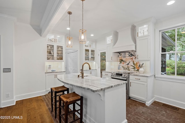 14 Fraser St, Beaufort, SC 29907 - kitchen featuring stainless steel range with electric cooktop, custom range hood, decorative backsplash, a kitchen island with sink, and recessed lighting