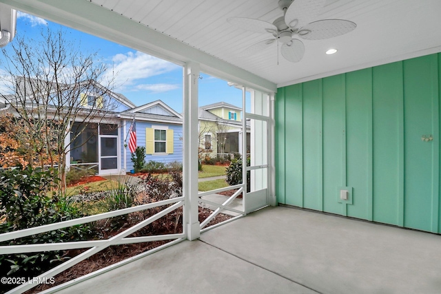 unfurnished sunroom with ceiling fan