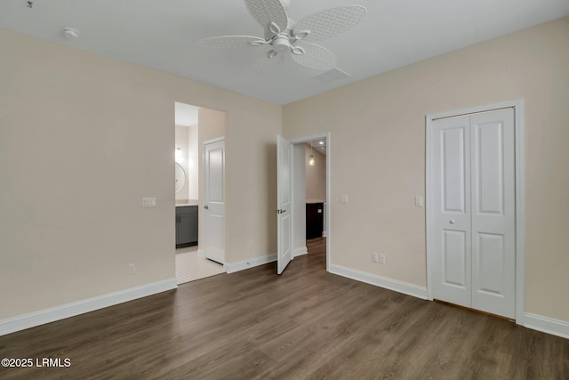 unfurnished bedroom featuring dark wood-type flooring, ceiling fan, and a closet