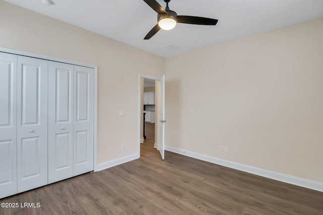 unfurnished bedroom with ceiling fan, hardwood / wood-style floors, and a closet