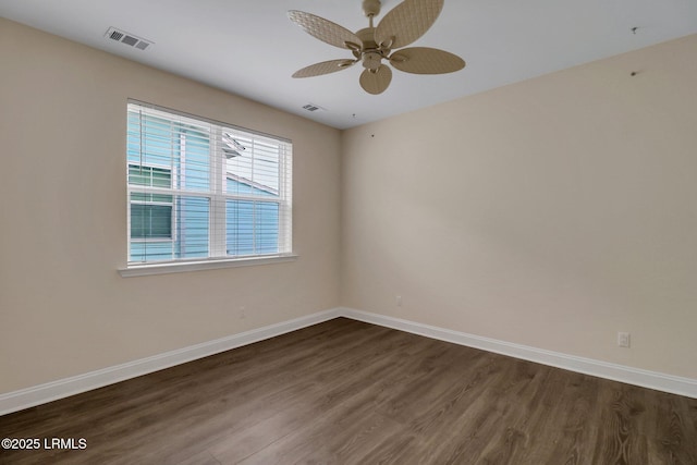 spare room featuring dark wood-type flooring and ceiling fan