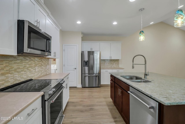 kitchen featuring stainless steel appliances, sink, pendant lighting, and backsplash