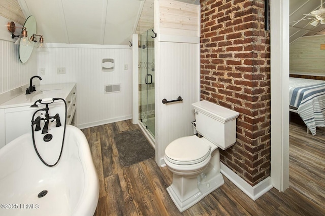 bathroom with hardwood / wood-style flooring, vaulted ceiling, a shower with door, and wood walls