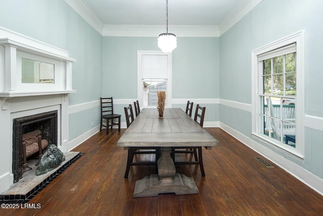 dining space with ornamental molding and dark hardwood / wood-style floors