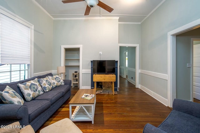 living room featuring ceiling fan, ornamental molding, and dark hardwood / wood-style floors