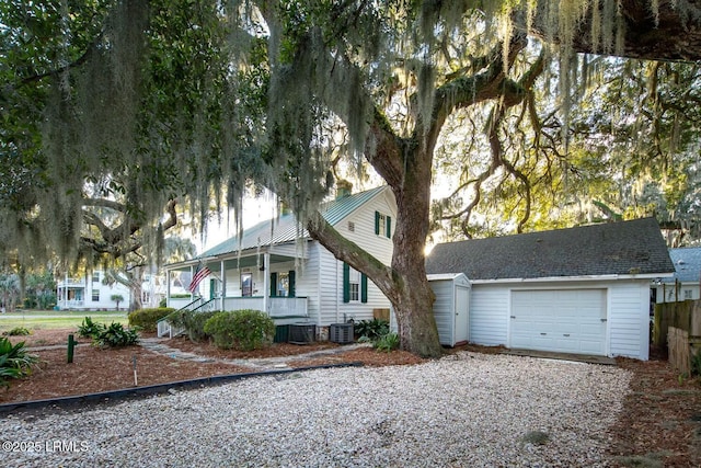 view of front facade with a porch, a garage, and central AC