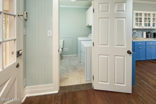 laundry room with independent washer and dryer, cabinets, and ornamental molding