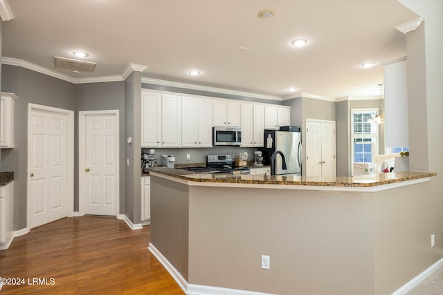 kitchen featuring white cabinetry, dark stone countertops, appliances with stainless steel finishes, kitchen peninsula, and hardwood / wood-style floors