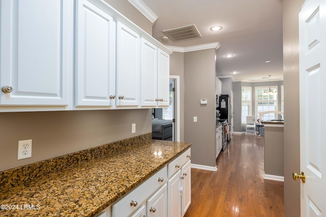 kitchen featuring white cabinetry, crown molding, hardwood / wood-style flooring, and dark stone countertops