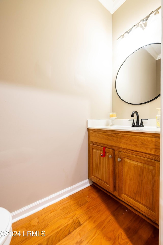 bathroom with vanity, toilet, and hardwood / wood-style floors