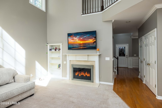 living room featuring a high ceiling, crown molding, and carpet floors