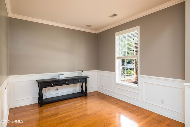 unfurnished room with crown molding and light wood-type flooring