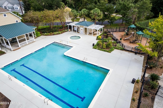 view of pool with a community hot tub, a pergola, a gazebo, a patio area, and a playground