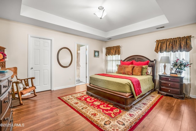 2 Waccamaw Way, Beaufort, SC 29906 - bedroom featuring a raised ceiling, wood finished floors, baseboards, and ensuite bathroom