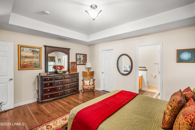 2 Waccamaw Way, Beaufort, SC 29906 - bedroom with wood finished floors, baseboards, a tray ceiling, and ensuite bath