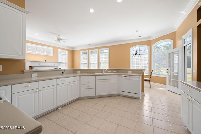 122 Island W Dr, Bluffton, SC 29910 - kitchen with white cabinets, light countertops, dishwasher, a sink, and crown molding
