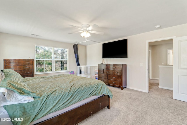 bedroom featuring a ceiling fan, visible vents, light carpet, and baseboards