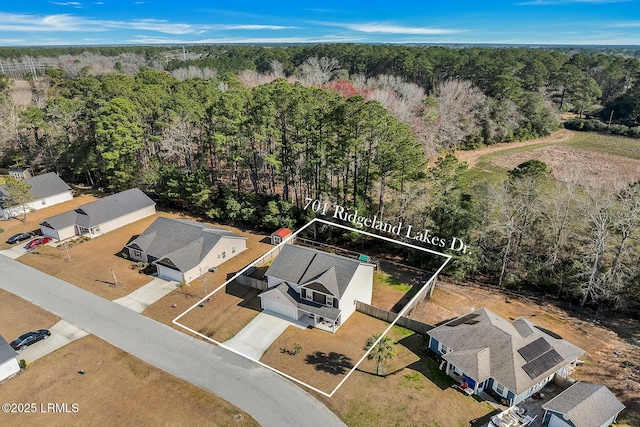 drone / aerial view featuring a residential view and a wooded view