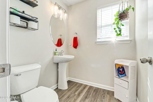 bathroom featuring wood finished floors, toilet, and baseboards