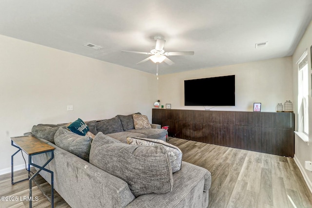 living room featuring visible vents, ceiling fan, and light wood finished floors