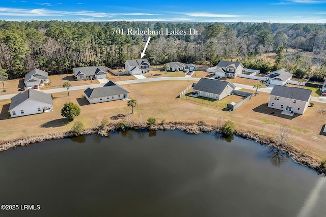 birds eye view of property with a water view and a forest view