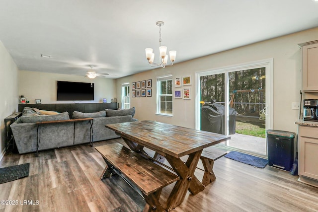 dining space featuring ceiling fan with notable chandelier and light wood-style floors