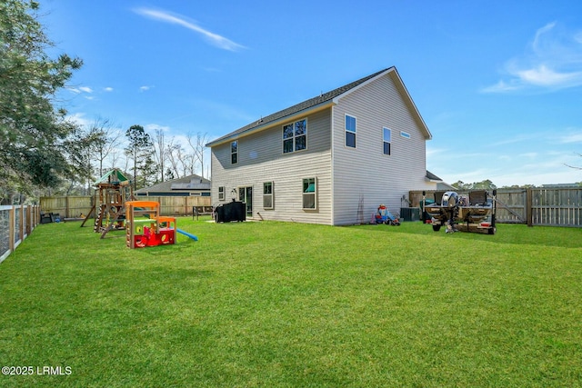 rear view of house with a playground, a yard, and a fenced backyard