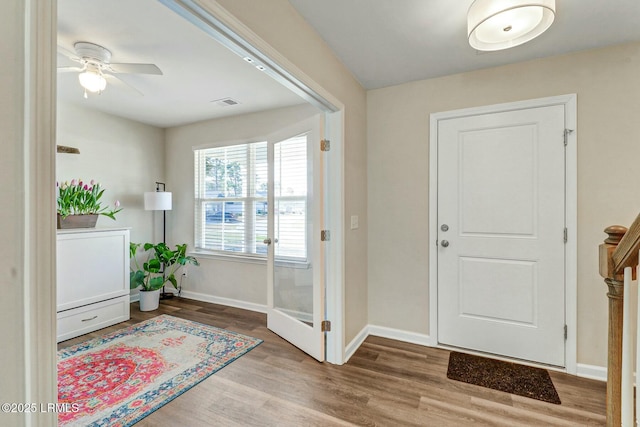 foyer with ceiling fan, wood finished floors, visible vents, and baseboards