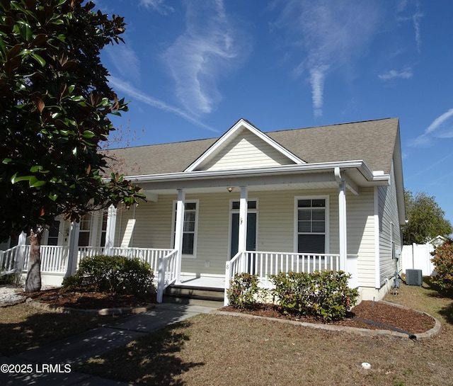 view of front of house with cooling unit, covered porch, and roof with shingles