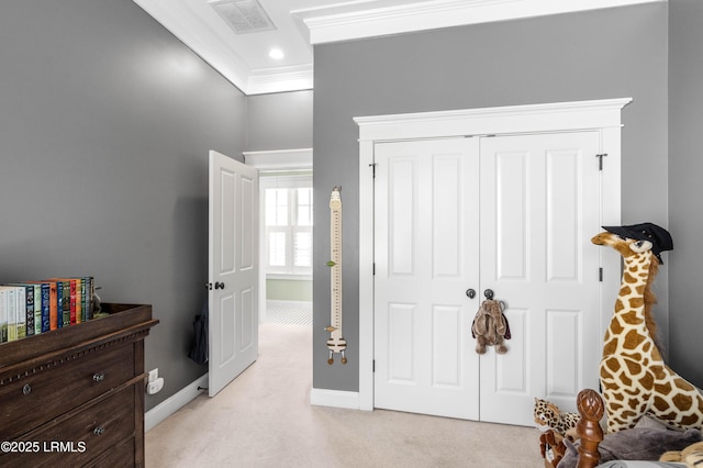 bedroom with ornamental molding, light colored carpet, baseboards, and a closet