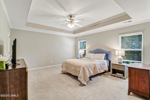 carpeted bedroom featuring crown molding, ceiling fan, and a raised ceiling