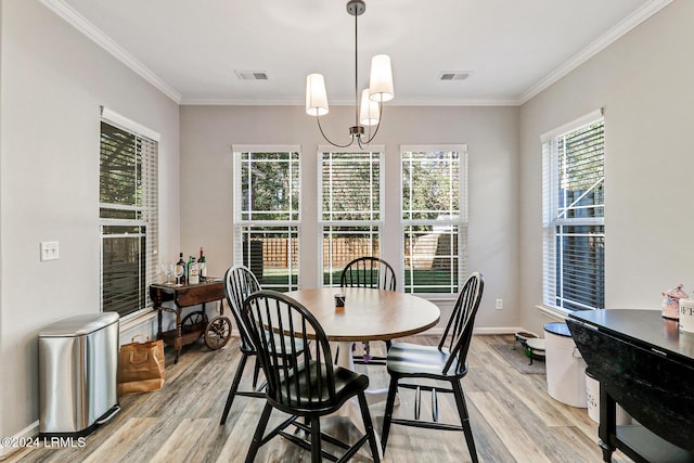 dining area with ornamental molding, light hardwood / wood-style floors, and a chandelier