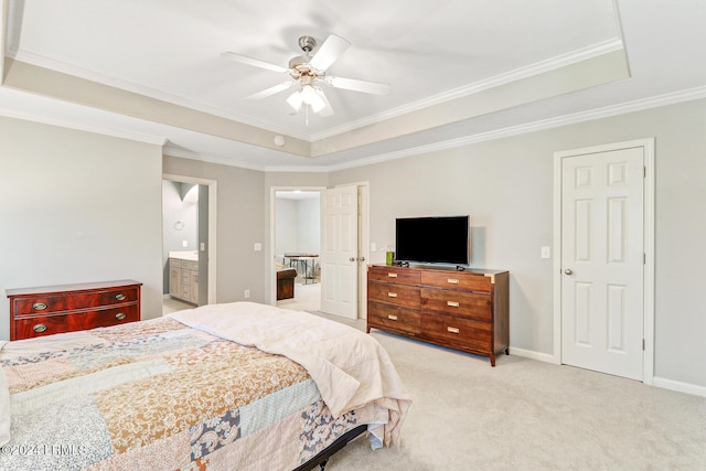 bedroom featuring ensuite bath, light carpet, ceiling fan, and a tray ceiling