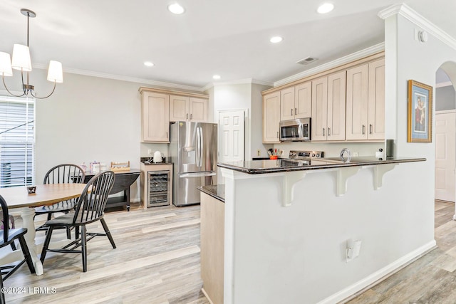 kitchen featuring pendant lighting, stainless steel appliances, wine cooler, kitchen peninsula, and light wood-type flooring