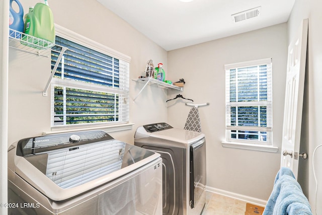 washroom with washer and clothes dryer and light tile patterned floors