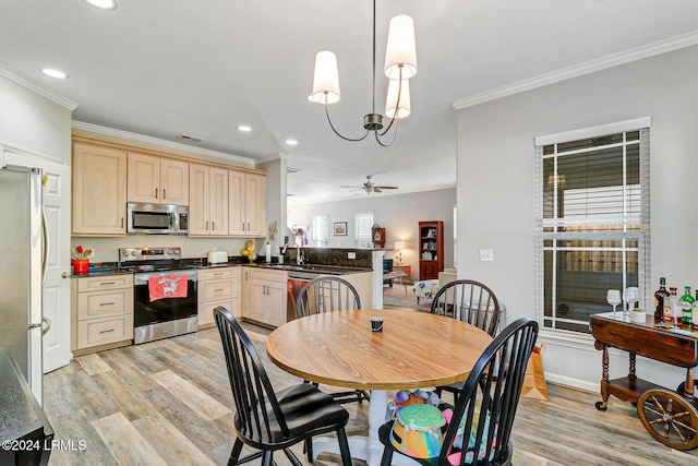 kitchen featuring sink, light hardwood / wood-style flooring, stainless steel appliances, decorative light fixtures, and kitchen peninsula