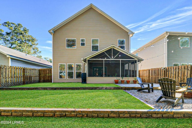 rear view of house with a yard and a sunroom